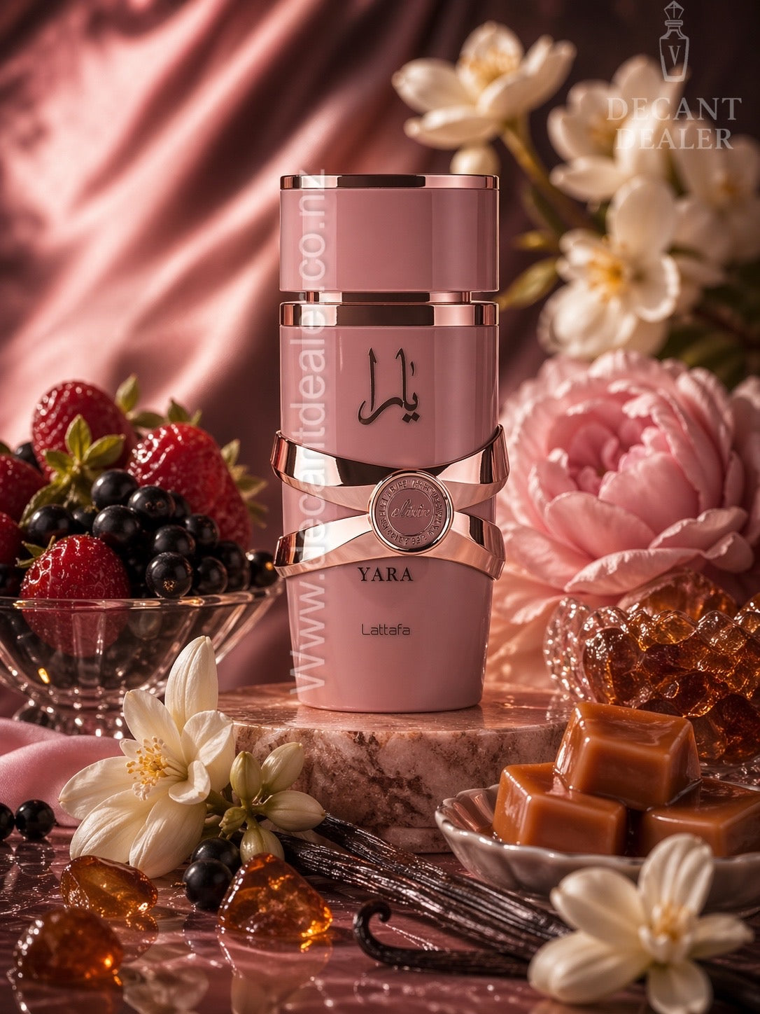 Pink and rose gold Yara perfume bottle with flowers, berries, and caramel in the background
